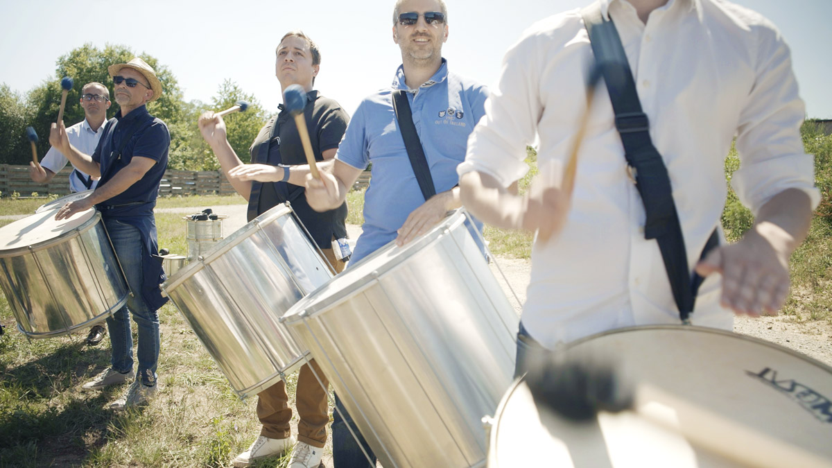 Collaborateurs jouant des surdos en plein air lors d'un atelier de percussions brésiliennes à Lyon