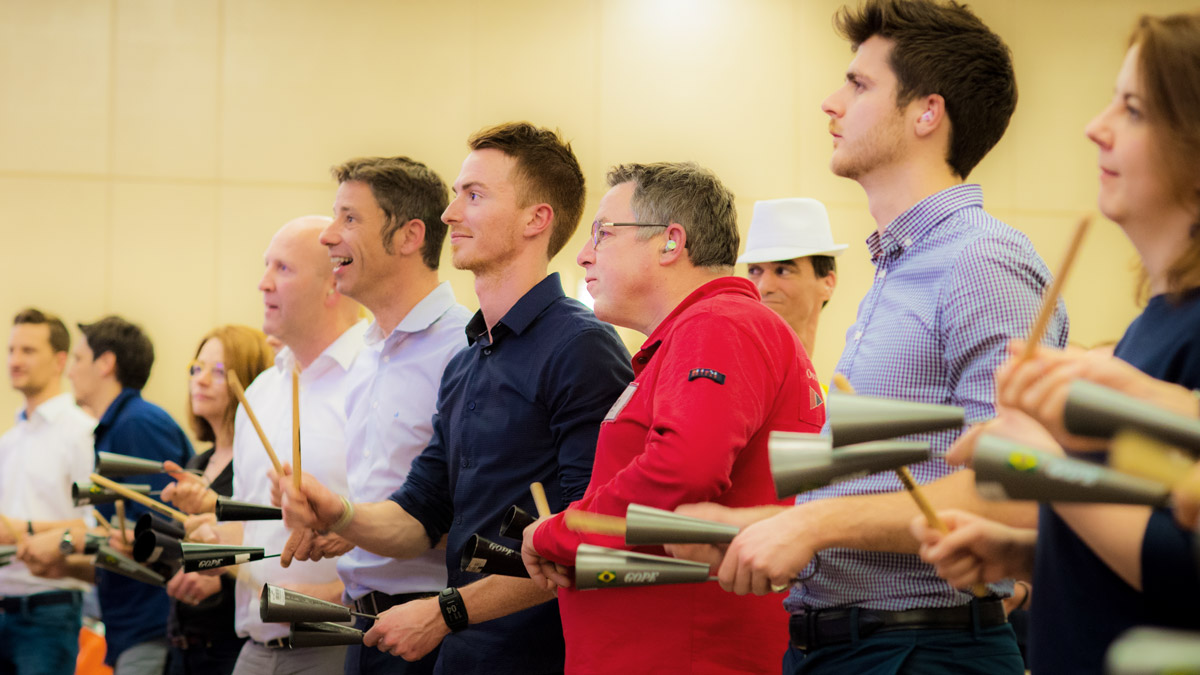 Participants jouant des agogôs lors d'un team building batucada à l'hôtel Hyatt Place Paris Charles de Gaulle
